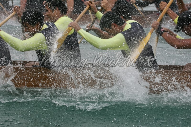 Dragon boat paddles splashing the water - Henning Wiekhorst