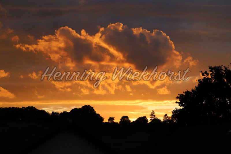 Orangener Sonnenuntergang über Hügeln - Henning Wiekhorst